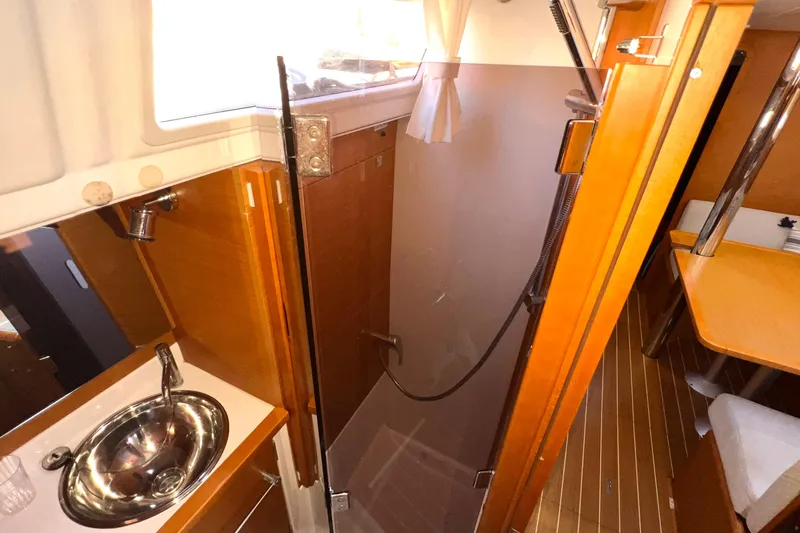 Slide: The Image of Interior of 2015 Jeanneau Sun Odyssey 379 yacht, featuring a compact bathroom with sink and shower. - 41