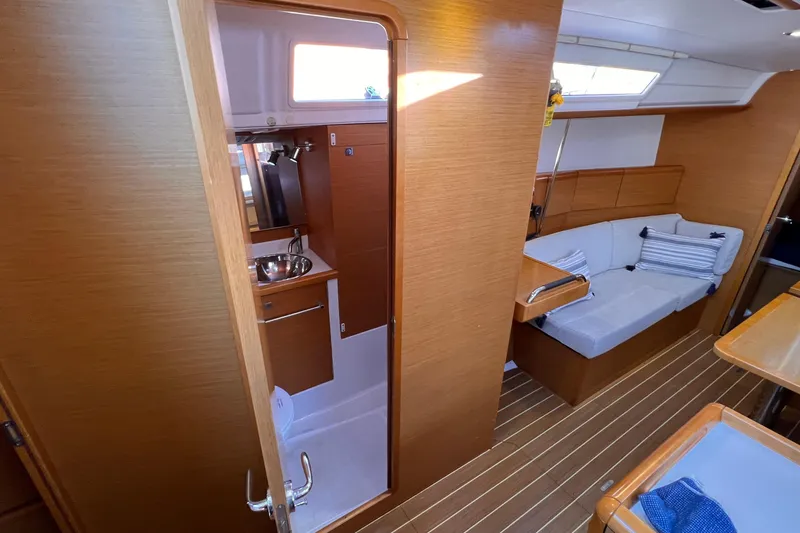 Slide: The Image of Interior of 2015 Jeanneau Sun Odyssey 379 sailboat, featuring cozy seating and compact bathroom. - 42