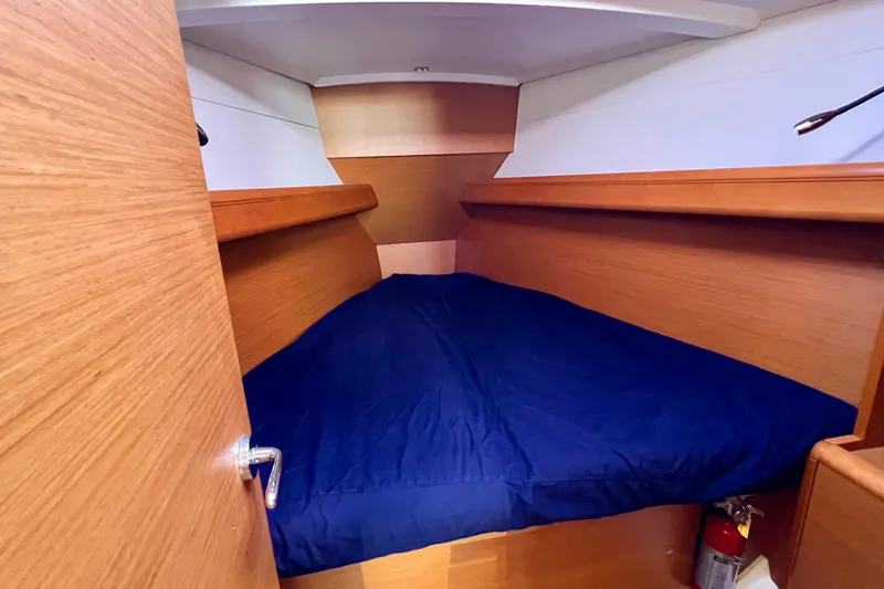 Slide: The Image of Cozy cabin interior of 2015 Jeanneau Sun Odyssey 379 sailboat with blue bedding. - 43