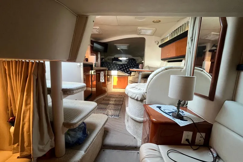 Slide: The Image of Interior of 2001 Sea Ray 340 Sundancer yacht, featuring cozy seating and elegant wood finishes. - 26