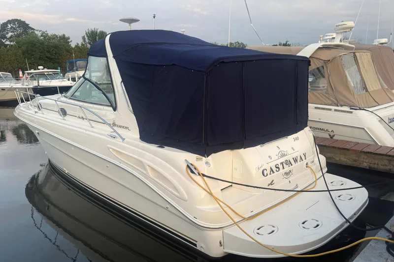 Slide: The Image of 2001 Sea Ray 340 Sundancer boat docked with navy blue cover. - 4