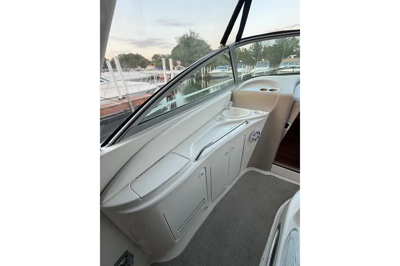 Slide: The Image of Interior view of 2001 Sea Ray 340 Sundancer boat, featuring sleek cabinetry and window. - 10