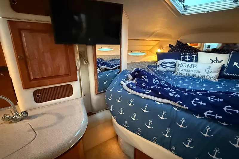 Slide: The Image of Cozy cabin interior of 2001 Sea Ray 340 Sundancer with nautical-themed bedding and decor. - 25