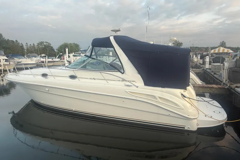 Slide: The Image of 2001 Sea Ray 340 Sundancer yacht docked at a marina under cloudy skies. - 2