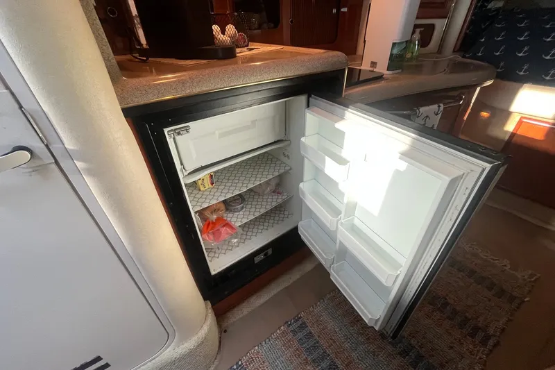 Slide: The Image of Open refrigerator inside 2001 Sea Ray 340 Sundancer yacht, showcasing interior storage space. - 29