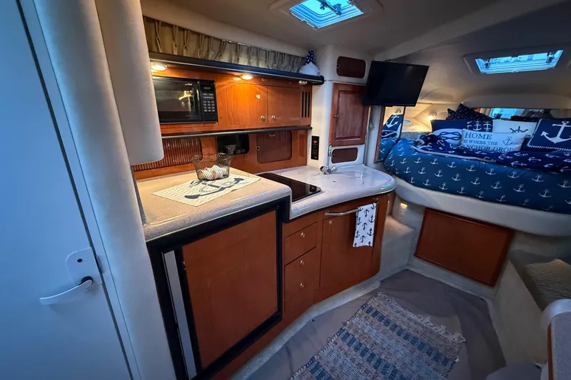 Slide: The Image of 2001 Sea Ray 340 Sundancer cabin interior with kitchenette and cozy sleeping area. - 23