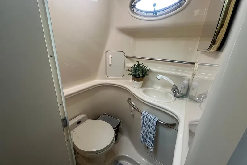 Slide: The Image of Compact bathroom in 2001 Sea Ray 340 Sundancer yacht with sink, toilet, and porthole window. - 31