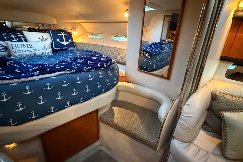 Slide: The Image of Cozy cabin interior of 2001 Sea Ray 340 Sundancer with nautical-themed bedding and decor. - 26