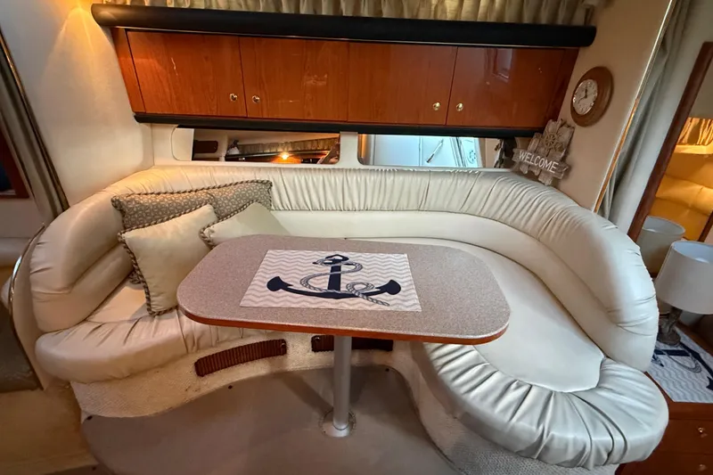 Slide: The Image of Interior of 2001 Sea Ray 340 Sundancer with cozy seating and nautical-themed decor. - 28
