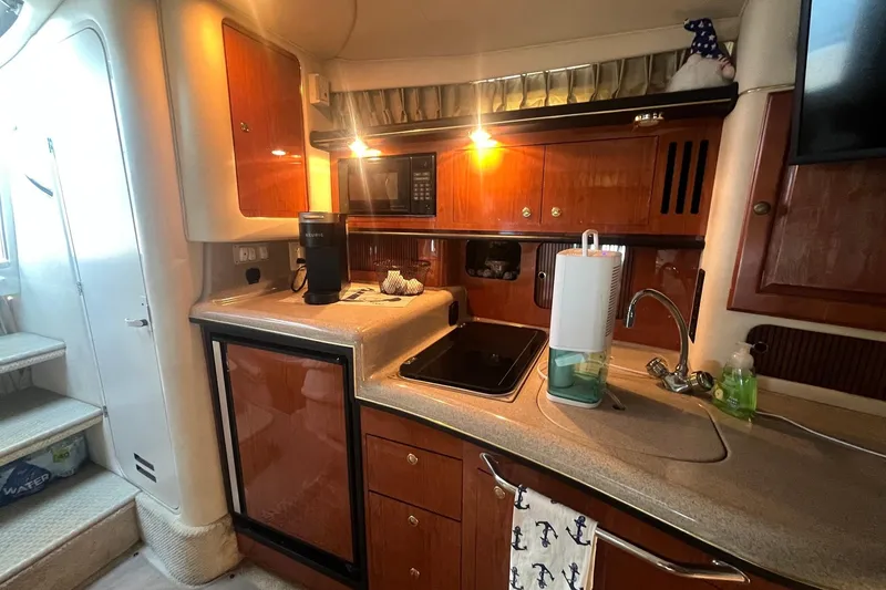 Slide: The Image of Interior of 2001 Sea Ray 340 Sundancer yacht kitchen with wooden cabinets and modern appliances. - 27