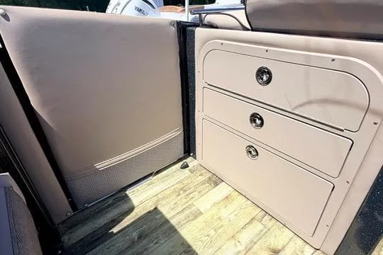 Slide: The Image of Interior view of 2020 Crest Savannah 250 SLS boat with storage drawers and wood flooring. - 15