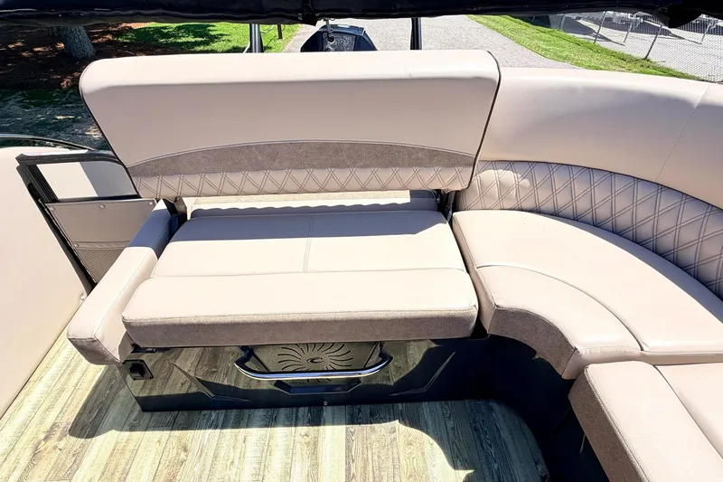 Slide: The Image of 2020 Crest Savannah 250 SLS boat interior with beige seating and wood-style flooring. - 7