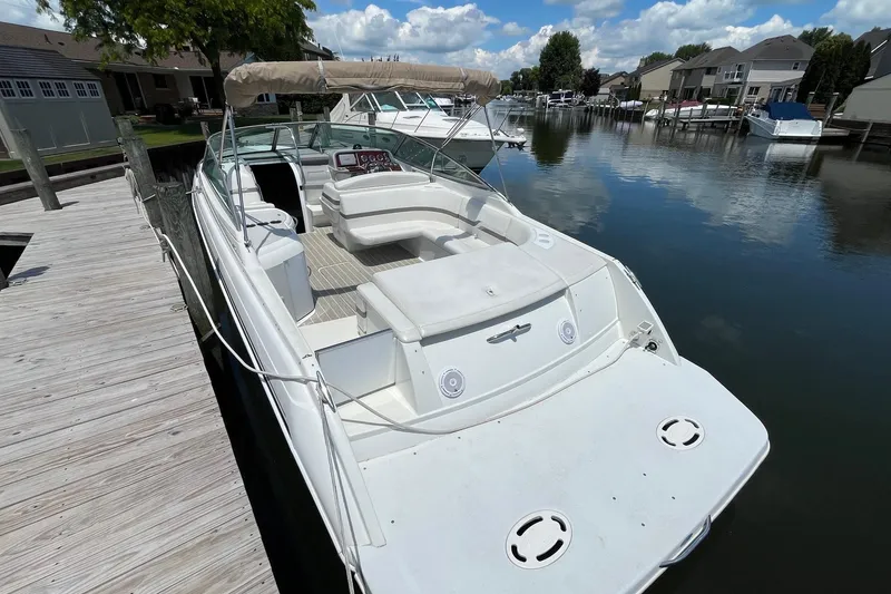 Slide: The Image of 2002 Formula 330 Sun Sport boat docked on a calm waterfront with clear skies. - 3