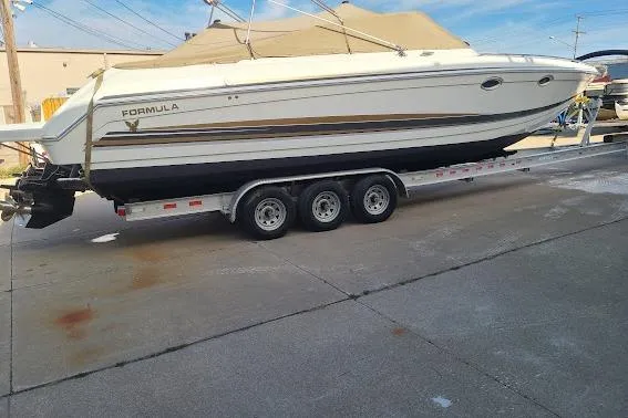 Slide: The Image of 2002 Formula 330 Sun Sport boat on a trailer, parked outdoors. - 37
