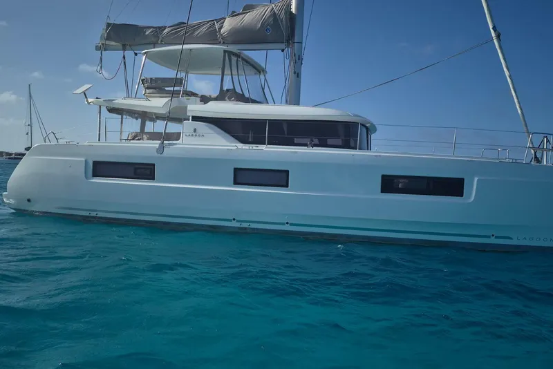 The Image of 2025 Lagoon 46 catamaran sailing on clear blue water. - 1