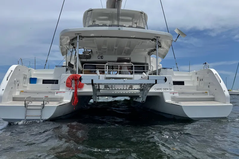 Slide: The Image of 2025 Lagoon 46 catamaran on water, rear view with clear sky background. - 10