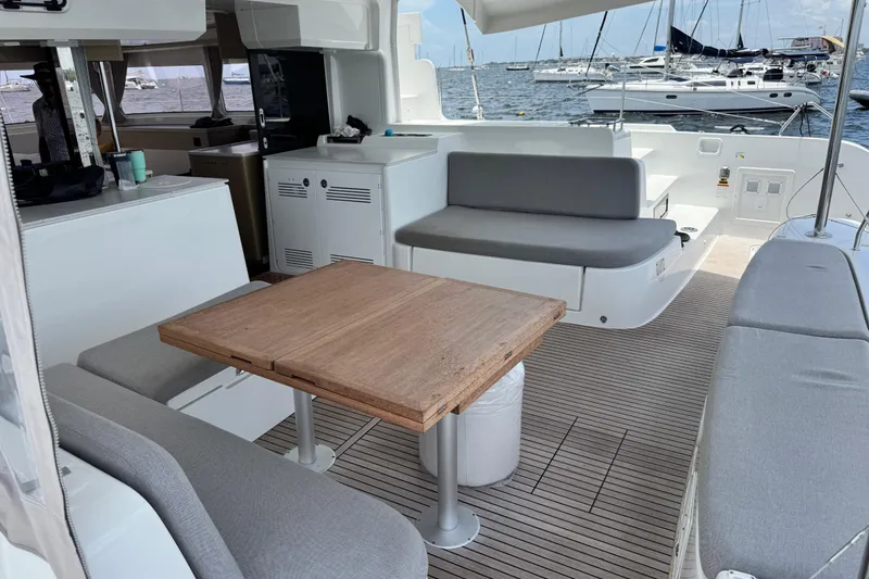 Slide: The Image of Modern Lagoon 46 catamaran interior with seating and table, docked at marina, 2025 model. - 17