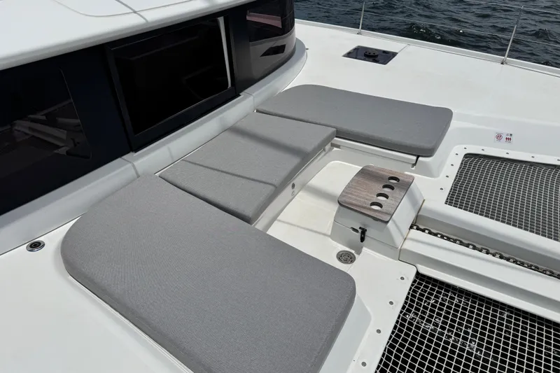 Slide: The Image of 2025 Lagoon 46 yacht deck with cushioned seating and netting over water. - 18