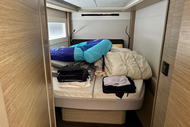 Slide: The Image of Cozy cabin interior of 2025 Lagoon 46 yacht with bedding and folded clothes. - 25