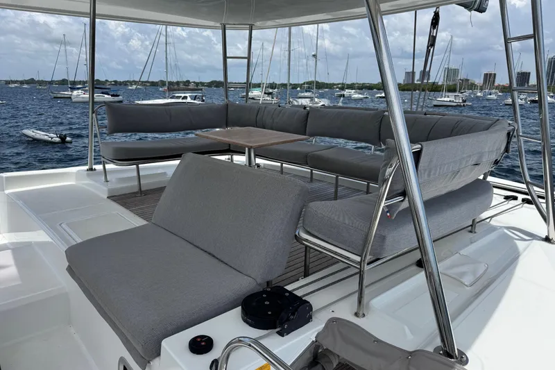 Slide: The Image of Luxurious Lagoon 46 catamaran deck with comfortable seating, overlooking a marina, 2025 model. - 42
