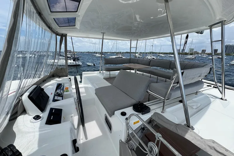 Slide: The Image of Luxurious 2025 Lagoon 46 catamaran with spacious seating and helm, docked in a marina. - 43