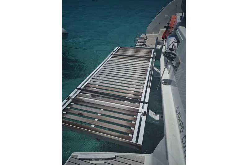 Slide: The Image of Boarding platform of 2025 Lagoon 46 yacht over clear blue water. - 7