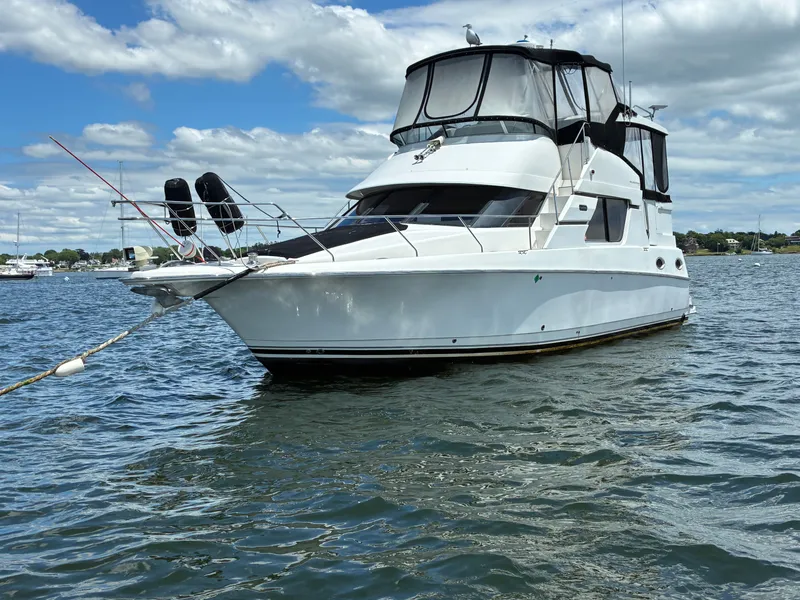 Slide: The Image of A 2001 Silverton 392 Motor Yacht floats on calm water under a cloudy sky. - 2