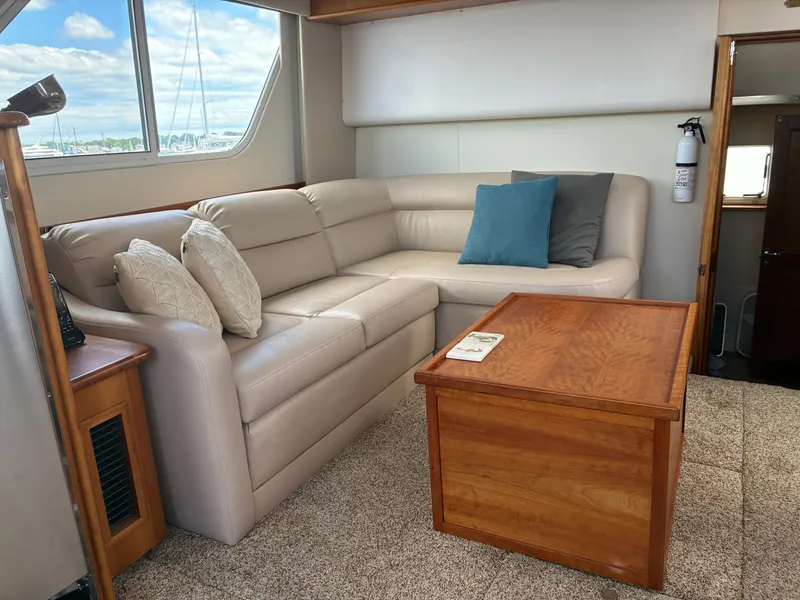 Slide: The Image of Interior of the 2001 Silverton 392 Motor Yacht with beige sofa and wooden table. - 23