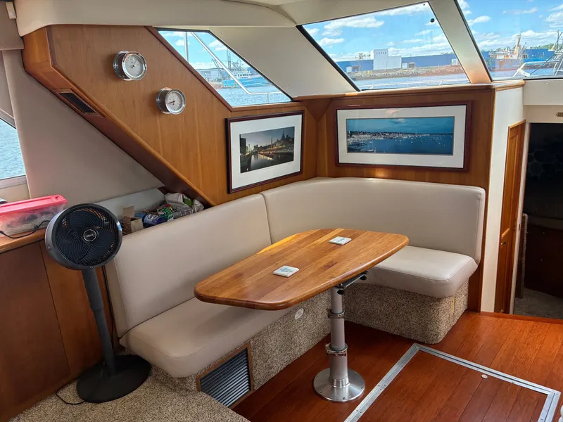 Slide: The Image of Interior of a 2001 Silverton 392 Motor Yacht with a cozy seating area and wooden table. - 25