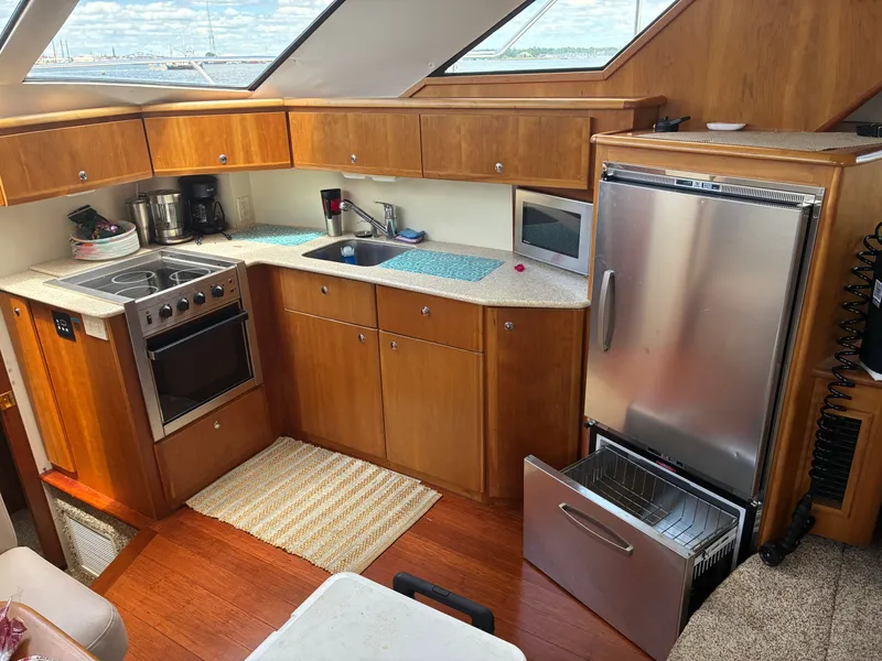Slide: The Image of Interior of the 2001 Silverton 392 Motor Yacht with kitchen, stove, sink, and refrigerator. - 26