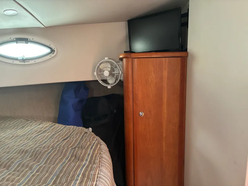 Slide: The Image of Interior of a 2001 Silverton 392 Motor Yacht with bed, cabinet, and TV. - 31