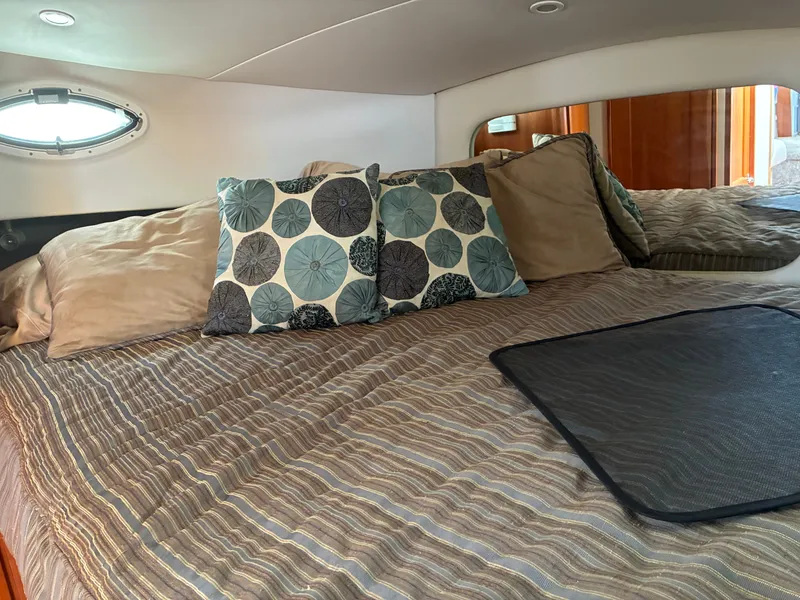 Slide: The Image of The image shows a cozy yacht bedroom with striped bedding and decorative pillows. - 33