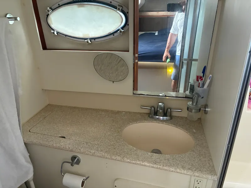Slide: The Image of Bathroom with sink, mirror, and porthole in a 2001 Silverton 392 Motor Yacht. - 37