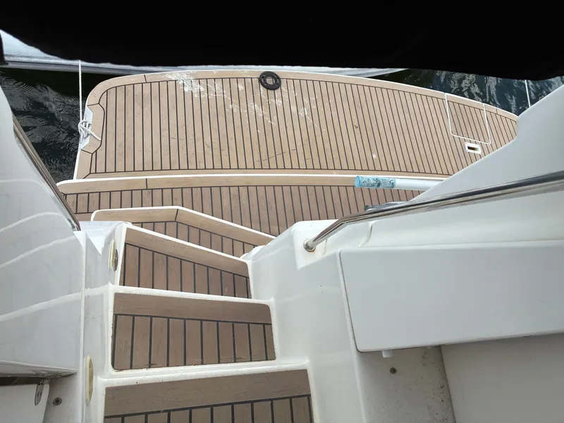 Slide: The Image of The stairs of a 2001 Silverton 392 Motor Yacht lead to a deck with wood-like finish. - 4