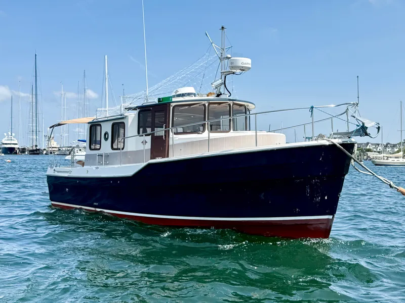 Slide: The Image of 2009 Ranger Tugs R-29 boat on water, clear sky, marina background. - 1