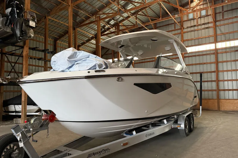 Slide: The Image of 2026 Yamaha Boats 295SD on trailer in a spacious indoor storage facility. - 0
