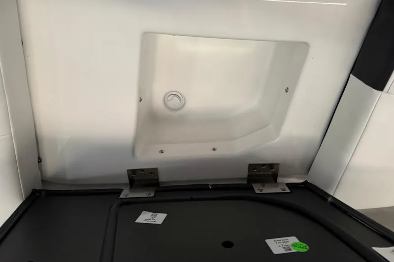 Slide: The Image of Interior compartment of 2026 Yamaha Boats 295SD, featuring storage space and metal hinges. - 16