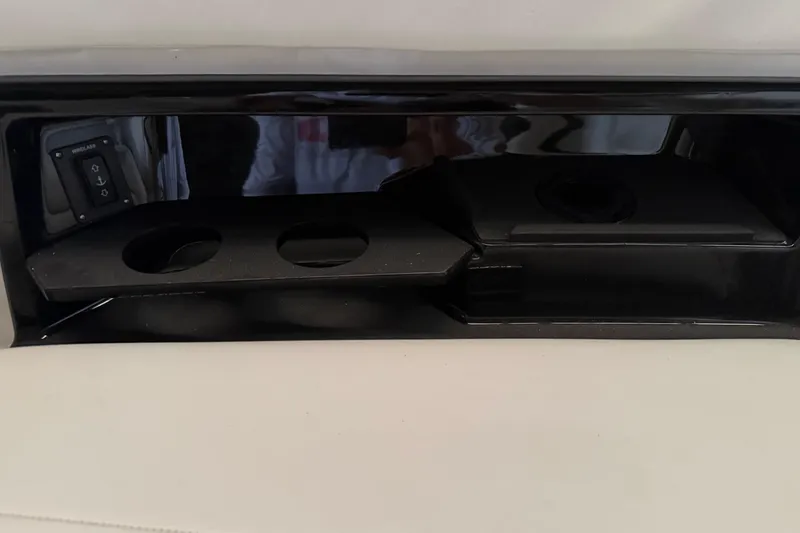 Slide: The Image of 2026 Yamaha Boats 295SD interior compartment with cup holders and control panel. - 17