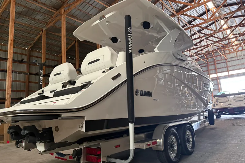 Slide: The Image of 2026 Yamaha Boats 295SD in a warehouse, showcasing sleek design and modern features. - 2