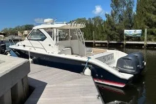 The Image of 2019 Pursuit OS 325 Offshore boat docked, featuring dual Yamaha engines and sleek design. - 1