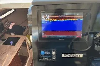 Slide: The Image of 2019 Pursuit OS 325 Offshore boat dashboard with electronic display and controls. - 12