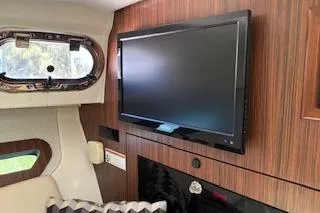 Slide: The Image of 2019 Pursuit OS 325 Offshore cabin interior with mounted TV and window view. - 18