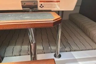 Slide: The Image of 2019 Pursuit OS 325 Offshore interior with wooden steps and cushioned seating. - 20