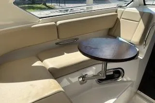 Slide: The Image of Interior seating area of 2019 Pursuit OS 325 Offshore boat with a small table. - 22