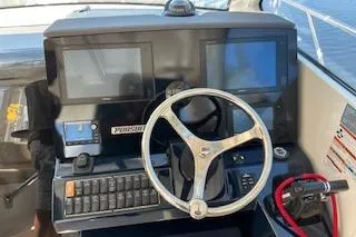 Slide: The Image of 2019 Pursuit OS 325 Offshore helm with dual screens and steering wheel. - 23