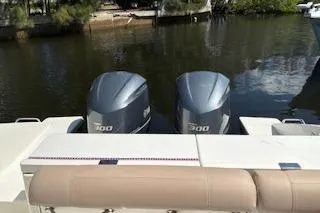 Slide: The Image of 2019 Pursuit OS 325 Offshore boat with dual 300 horsepower engines docked by a serene waterfront. - 5