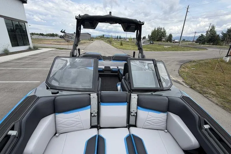 Slide: The Image of 2026 Supra SA boat interior with modern seating and sleek design in a parking area. - 13