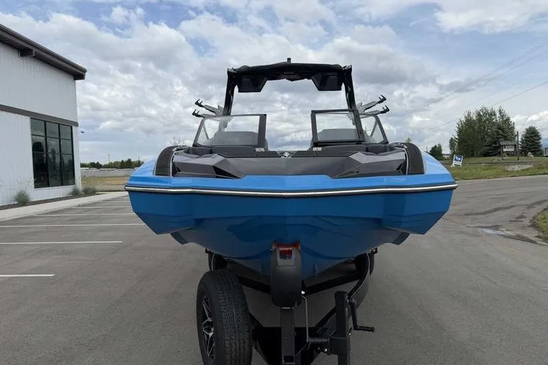 Slide: The Image of 2026 Supra SA boat in blue on trailer, parked outdoors under cloudy sky. - 11