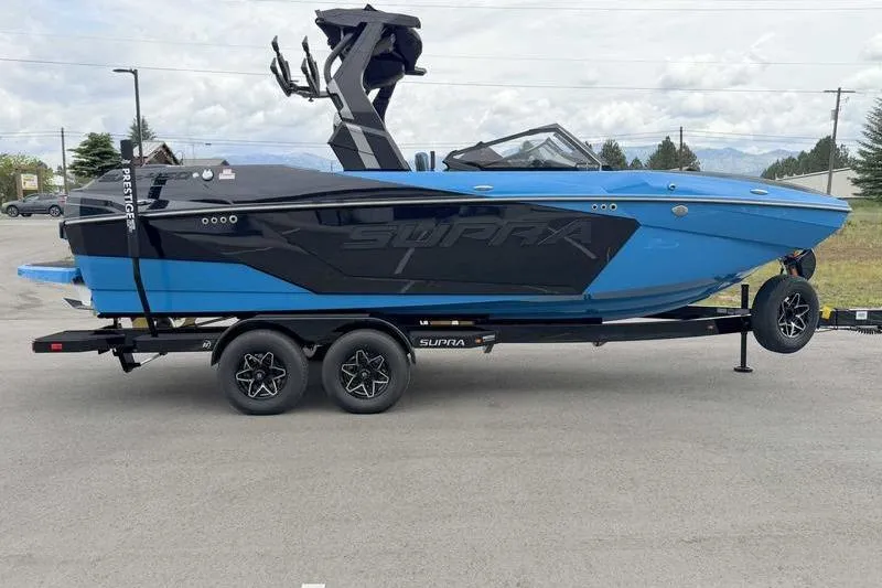 Slide: The Image of 2026 Supra SA boat in blue and black on a trailer, parked outdoors. - 5
