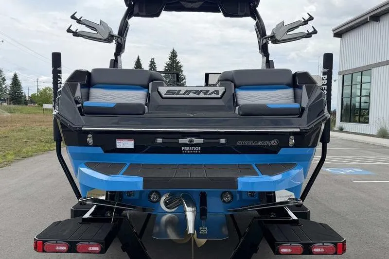Slide: The Image of 2026 Supra SA boat rear view, featuring sleek design and blue accents in a parking area. - 8